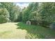 Large, grassy backyard featuring a storage shed and mature trees at 359 Dallas St, Hiram, GA 30141