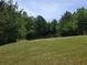 Picturesque view of a tranquil lake surrounded by lush trees and a well-maintained grassy lawn at 3623 Terrah Point Dr, Duluth, GA 30097