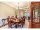 Elegant dining room with a large wooden table, decorative chandelier, and adjacent living space at 3623 Terrah Point Dr, Duluth, GA 30097