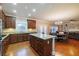 Modern kitchen island with granite countertops and dark wood cabinets leading to a cozy living room at 3623 Terrah Point Dr, Duluth, GA 30097