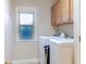 Laundry room with window, washer, and dryer with overhead cabinet storage at 3623 Terrah Point Dr, Duluth, GA 30097