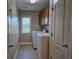 Well-lit laundry room with tile flooring, washer, dryer, and built-in cabinetry for storage at 3623 Terrah Point Dr, Duluth, GA 30097