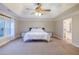Large main bedroom with tray ceiling, ceiling fan, and view of en-suite bath and walk-in closet at 3623 Terrah Point Dr, Duluth, GA 30097