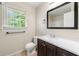 Bathroom with modern vanity, framed mirror, and window providing natural light and ventilation at 6553 Parkside Way, Tucker, GA 30084