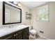 Bright bathroom with dark vanity, modern countertop, framed mirror and natural light from the window at 6553 Parkside Way, Tucker, GA 30084