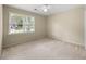 Neutral bedroom with a large window, ceiling fan, and plush carpet for a cozy feel at 6553 Parkside Way, Tucker, GA 30084