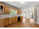 Open kitchen with wood cabinets, laminate floor, and natural light; flows into the living and dining areas at 6553 Parkside Way, Tucker, GA 30084