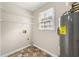 Practical laundry room with storage shelves, water heater, and a window for ventilation at 6553 Parkside Way, Tucker, GA 30084
