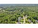 Aerial view of a home nestled among mature trees in a serene neighborhood at 6890 Autumn Hills Dr, Cumming, GA 30028