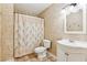 Neutral bathroom with a white sink vanity, decorative mirror, and a shower/tub with a tropical patterned curtain at 6890 Autumn Hills Dr, Cumming, GA 30028
