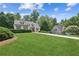 Charming home with a lush green lawn, mature trees, and a long driveway at 6890 Autumn Hills Dr, Cumming, GA 30028