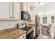 Modern kitchen with granite countertops, stainless steel appliances, and a breakfast nook with natural light at 6890 Autumn Hills Dr, Cumming, GA 30028