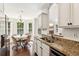 Well-lit kitchen featuring granite countertops, white cabinets, stainless steel appliances, and breakfast area at 6890 Autumn Hills Dr, Cumming, GA 30028