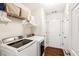 Bright laundry room with white washer and dryer, shelving and hardwood flooring at 6890 Autumn Hills Dr, Cumming, GA 30028