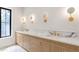 Bathroom featuring double vanity, marble countertop, custom sconces, and natural light at 130 Nova Ln, Roswell, GA 30075