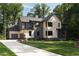 Modern two-story home with a combination of light and dark siding, attached garage, and well-maintained lawn at 130 Nova Ln, Roswell, GA 30075