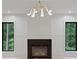 Bright room features fireplace with black trim, modern light fixture, white walls, and large windows at 130 Nova Ln, Roswell, GA 30075