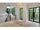 Bright foyer features staircase, hardwood floors, modern light fixture, and black frame windows with wooded views at 130 Nova Ln, Roswell, GA 30075