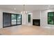 Open-concept living room with wood floors, black fireplace, access to back deck, and modern light fixture at 130 Nova Ln, Roswell, GA 30075