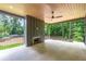 A spacious covered porch with a ceiling fan and stone flooring offers serene outdoor living with a fireplace at 130 Nova Ln, Roswell, GA 30075