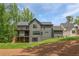 Stunning view of the home's rear exterior featuring a modern design, multi-level decks, and lush landscaping at 130 Nova Ln, Roswell, GA 30075