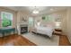 Relaxing bedroom featuring natural light, a fireplace, light walls, hardwood floors, and custom lighting at 417 S Candler St, Decatur, GA 30030