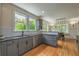 Modern kitchen featuring gray cabinets, quartz countertops, stainless steel appliances, and hardwood floors at 417 S Candler St, Decatur, GA 30030