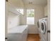 Bright laundry room featuring modern washer and dryer, freezer, and ample storage cabinets at 417 S Candler St, Decatur, GA 30030