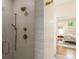 Tiled shower featuring a glass door, custom fixtures, and views of the primary bedroom at 417 S Candler St, Decatur, GA 30030