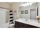 Bathroom with a single sink vanity, toilet, and shower with a black and white striped curtain at 106 Logan Pass Dr, Loganville, GA 30052