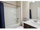 Bathroom featuring a shower-tub combo and a dark vanity at 106 Logan Pass Dr, Loganville, GA 30052