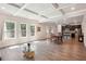 Open-concept living room showcasing hardwood floors, coffered ceilings, and seamless transition to the kitchen at 106 Logan Pass Dr, Loganville, GA 30052