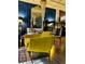 A stylish living room features a yellow velvet chair, decorative mirror, and dark paneled walls at 3180 Mathieson Drive # 502, Atlanta, GA 30305
