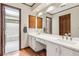 Modern bathroom with double vanity, white countertops, and wood trim at 6165 Pin Oak Ln, Alpharetta, GA 30005