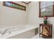 Bright bathroom features a soaking tub and window with wooded view at 6165 Pin Oak Ln, Alpharetta, GA 30005