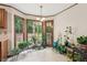 Bright breakfast nook surrounded by windows, filled with lush greenery and plants at 6165 Pin Oak Ln, Alpharetta, GA 30005