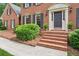 Inviting front entrance featuring brick steps, tasteful landscaping and sconce lighting at 6165 Pin Oak Ln, Alpharetta, GA 30005