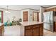 Kitchen island with granite countertop, stainless steel refrigerator and plentiful natural light at 6165 Pin Oak Ln, Alpharetta, GA 30005