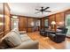 Living room with hardwood floors, wood paneling, a ceiling fan, and comfortable furniture at 6165 Pin Oak Ln, Alpharetta, GA 30005