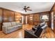 Well-lit living room with wood paneling, ceiling fan, and hardwood floors at 6165 Pin Oak Ln, Alpharetta, GA 30005