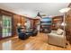 Cozy living room with wood paneling, fireplace, built-in shelving, and hardwood floors at 6165 Pin Oak Ln, Alpharetta, GA 30005