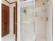 Clean shower featuring glass doors, bright tiles and storage niche at 6165 Pin Oak Ln, Alpharetta, GA 30005