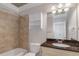 Bathroom featuring a tiled shower, granite countertop, and vanity with storage at 1786 Dekalb Ne Ave, Atlanta, GA 30307