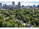 Aerial view of home in neighborhood with wooded surroundings and city skyline in distance at 21 Barksdale Ne Dr, Atlanta, GA 30309