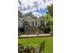 Grassy backyard with seating area on elevated stone patio and staircase at 21 Barksdale Ne Dr, Atlanta, GA 30309