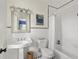 Bright bathroom featuring white tiled walls, a pedestal sink, and classic black and white tile flooring at 21 Barksdale Ne Dr, Atlanta, GA 30309