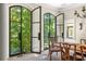 Bright dining room with black-framed windows overlooking lush greenery, with an ornate chandelier at 21 Barksdale Ne Dr, Atlanta, GA 30309