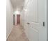Well-lit hallway with neutral carpet and multiple closet doors for ample storage space at 2252 Talmai Dr, Snellville, GA 30078