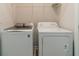 Efficient laundry room with modern washer and dryer units, and overhead storage at 2252 Talmai Dr, Snellville, GA 30078