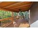 A covered back porch with wood flooring, ceiling fan, and a wood railing at 389 Oglesby Bridge Se Rd, Conyers, GA 30094